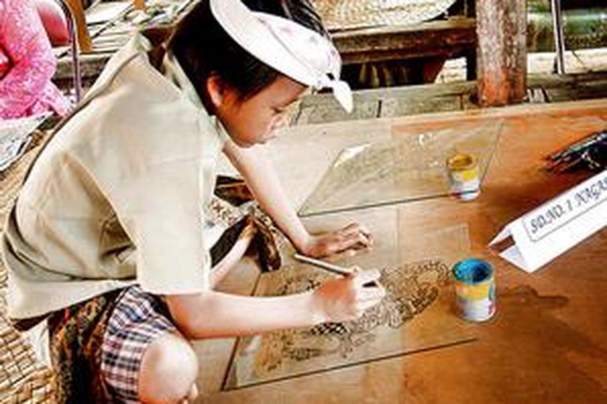 Ilustrasi: Seorang anak Bali melukis di atas kaca.