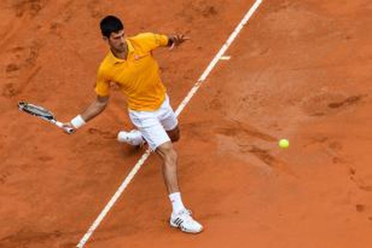 Petenis Serbia, Novak Djokovic, mengembalikan bola pemain Jepang, Kei Nishikori, saat bertemu pada perempat final Roma Masters, Jumat (15/5/2015). Djokovic menang 6-3, 3-5, 6-1.
