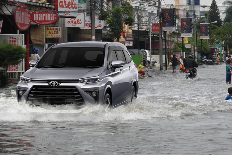 Mobil yang melintasi banjir rob.