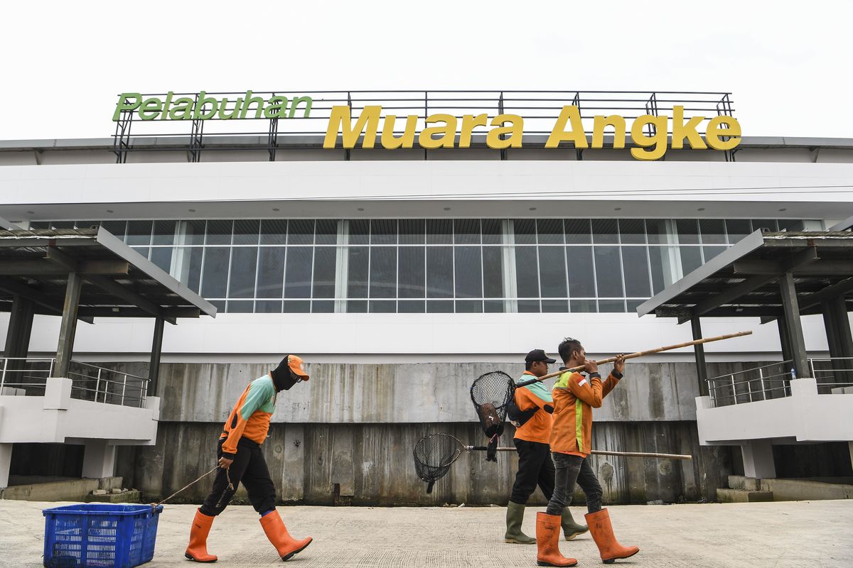 Petugas kebersihan melintas di depan gedung Pelabuhan Kali Adem Muara Angke, Jakarta, Jumat (1/4/2022). Proses pembangunan gedung baru pelabuhan  yang sempat terhenti akibat COVID-19 itu akan segera diresmikan dan dioperasikan untuk meningkatkan kenyamanan penumpang yang akan menyeberang ke Kepulauan Seribu. ANTARA FOTO/Hafidz Mubarak A/aww.