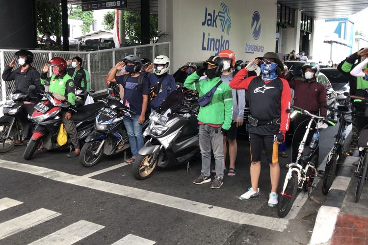 Sejumlah pengendara berhenti dan memberikan penghormatan saat lagu 17 Agustus berkumandang di perempatan CSW, Kebayoran Baru, Jakarta Selatan pada Selasa (17/8/2021) pukul 10.17 WIB.
