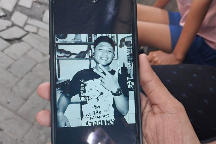 Ayu Komang (31), menunjukkan foto suaminya, Kadek Pawarta (31), melalui ponsel di rumahnya di Jalan Nanga Utara, Kota Denpasar, Bali, pada Selasa (18/2/2025). Kadek merupakan korban pembunuhan oleh tersangka Bastomi Prasetyawan alias Mas Pras, (38). 