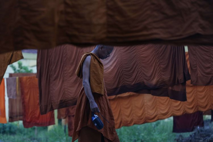 Biksu berdiri di antara jemuran jubah di Klenteng Tjeng Gie Bio Ulujami, Kabupaten Pemalang, Jawa Tengah saat ritual thudong, Rabu (24/5/2023). Sebanyak 32 biksu jalan kaki dari Thailand menuju Candi Borobudur untuk meyambut Hari Raya Waisak.