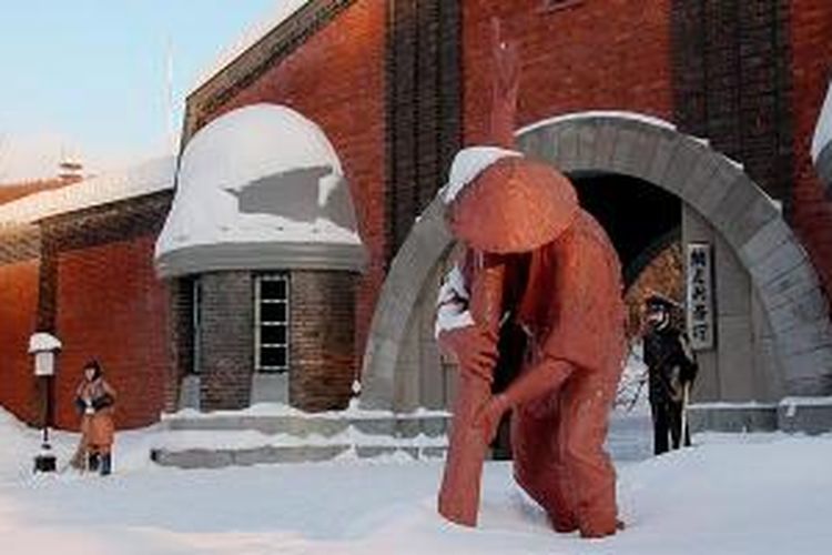 Patung napi sedang bekerja di depan pintu gerbang Museum Penjara Abashiri, Hokkaido, Jepang.