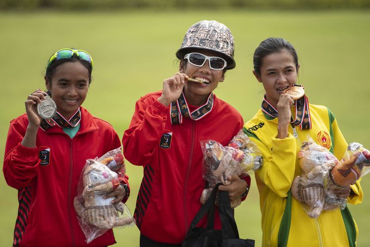 Atlet DKI Jakarta Odekta Elvina Naibaho (tengah) dan Tryaningsih (kiri) serta atlet Kalimantan Timur Irma Handayani (kanan) menunjukkan medali nomor lari maraton putri PON XX Papua di kompleks Freeport, Kuala Kencana, Kabupaten Mimika, Papua, Sabtu (9/10/2021). Odekta Elviani berhasil meraih medali emas, sementara pelari putri DKI Jakarta lainnya Tryaningsih meraih medali perak dan pelari putri Kalimantan Timur Irma Handayani meraih medali perunggu.