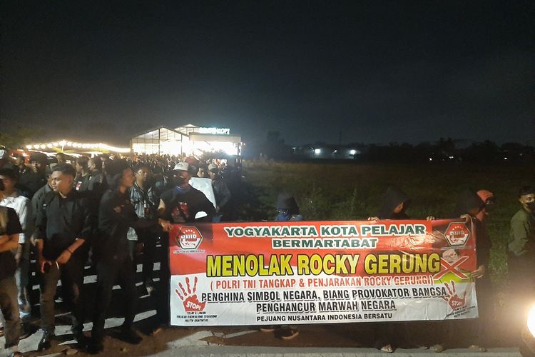 Massa membentangkan spanduk menolak kehadiran Rocky Gerung menjadi pembicara yang digelar di Bento Kopi, Sleman.