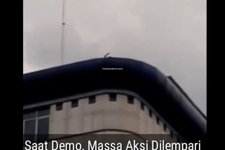 Tangkapan layar video pelemparan batu dari atas gedung DPRD Kota Medan saat terjadi aksi unjuk rasa rusuh di DPRD Sumut pada Kamis (8/10/2020). Polisi memastikan sudah mengantongi identitas pelaku dan bukan dari polisi.