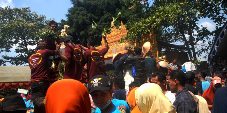 Warga Desa Sumber Jatipohon, Kecamatan Grobogan, Kabupaten Grobogan, Jawa Tengah berebut Gunungan setinggi 2,5 meter dalam tradisi sedekah bumi di obyek wisata Jatipohon, Grobogan, Kamis (9/8/2018).