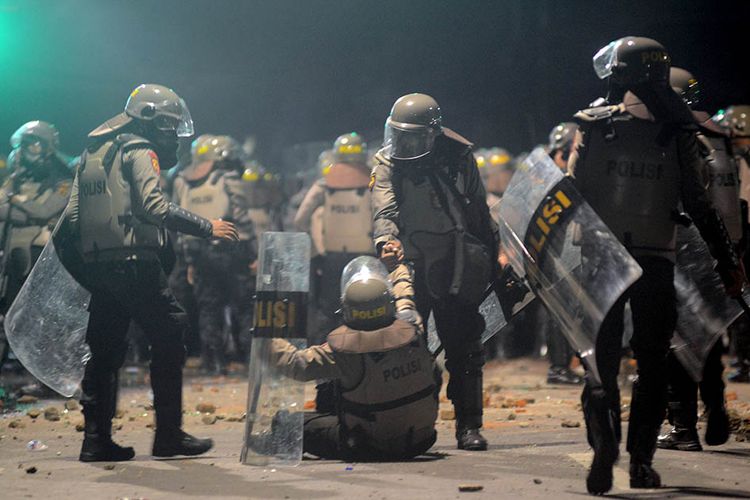 Personel Kepolisian beristirahat saat kericuhan Aksi 22 Mei yang terjadi di Jalan Brigjen Katamso, Slipi, Jakarta, Rabu (22/5/2019).