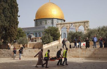 Warga Palestina mengevakuasi seorang pria yang terluka selama bentrokan dengan pasukan keamanan Israel di kompleks Masjid Al-Aqsa, Yerusalem Senin,(10/5/2021). Polisi Israel kembali bentrok dengan pengunjuk rasa Palestina di tempat tersebut pada Senin. Petugas medis Palestina mengatakan setidaknya 180 warga Palestina terluka dalam kekerasan di kompleks Masjid Al-Aqsa, termasuk 80 orang yang dirawat di rumah sakit.