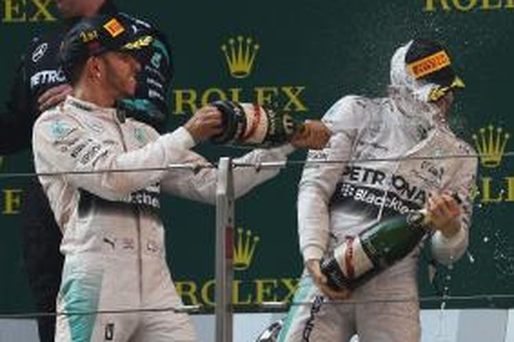 Pebalap Mercedes, Lewis Hamilton (kiri) dan Nico Rosberg, merayakan finis podium mereka di Sirkuit Shanghai setelah finis pertama dan kedua pada GP China, Minggu (12/4/2015).