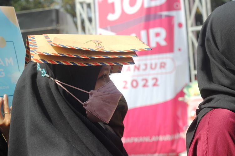Ilustrasi - Seorang pencari kerja menjunjung berkas lamaran kerja saat momen job fair di Kabupaten Cianjur, Jawa Barat