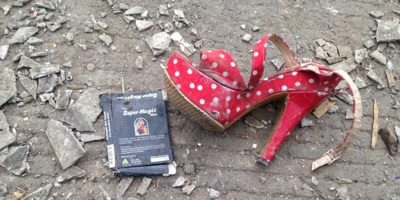 Tampak sepatu hak merah sebelah kiri yang terserak di tengah reruntuhan bangunan Kalijodo saat digusur, Senin (29/2/2016). 


