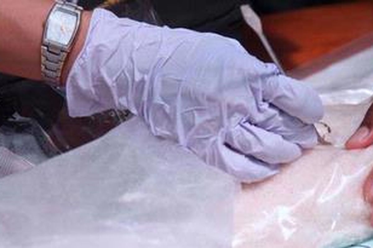 Petugas mengambil sampel barang bukti sabu-sabu untuk dites keasliannya sebelum dimusnahkan di Badan Narkotika Nasional, Jakarta Timur, Senin (11/3/2013). Hari itu lebih dari 7,2 kilogram sabu yang disita oleh BNN dari seorang tersangka di Medan, Sumatera Utara, dimusnahkan. Sejak Januari 2013 lalu, BNN telah memusnahkan lebih dari 11 kilogram sabu dan 0,4 gram heroin. KOMPAS/WISNU WIDIANTORO