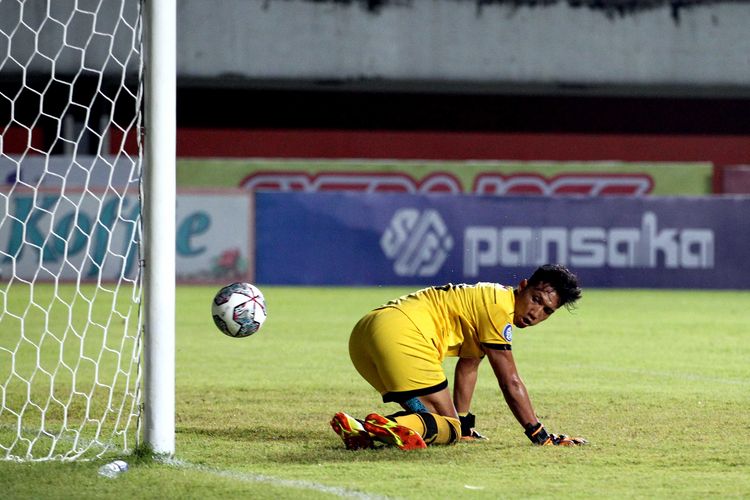 Bola terlepas dari kendali penjaga gawang Persela Lamongan Dwi Kuswanto yang ditembakkan pemain Persebaya Surabaya pada pekan ke 8 Liga 1 2021 dan berakhir dengan skor 1-1 di Stadion Maguwoharjo Sleman, Kamis (21/10/2021) malam.