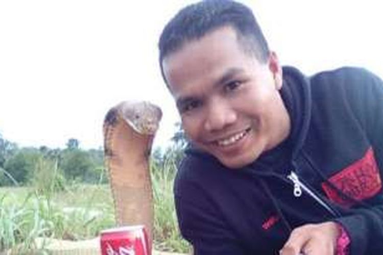 Abu Zarin Hussin berfoto narsis bersama ular kobra, salah satu dari empat ular miliknya.
