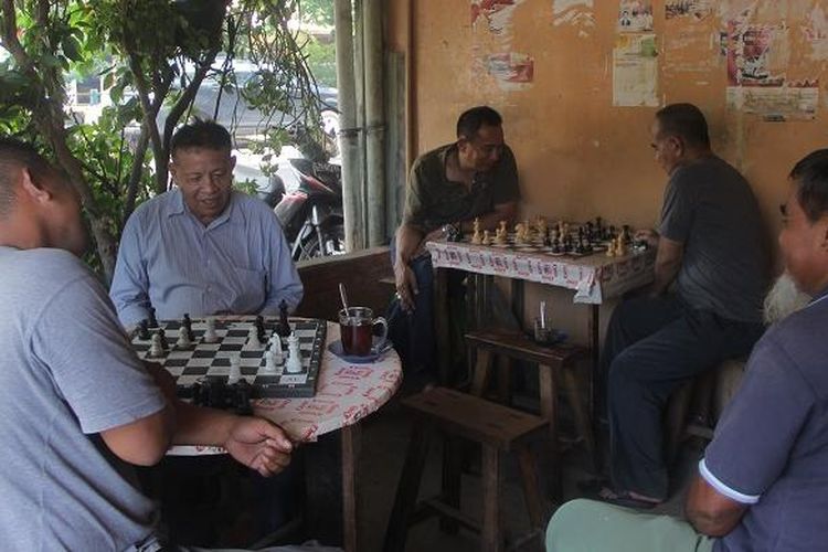 Pengunjung menikmati kopi sambil bermain catur di Warung Kopi Kong Djie, Belitung, Kamis (10/3/2016).