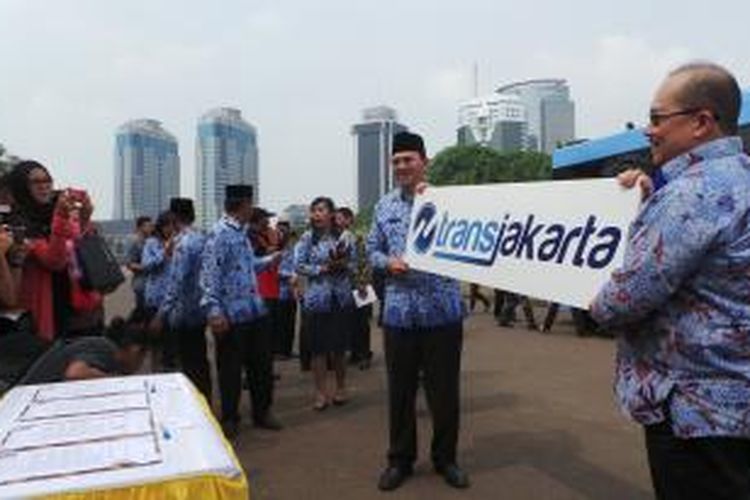 Plt Gubernur DKI Jakarta Basuki Tjahaja Purnama bersama Dirut PT Transjakarta ANS Kosasih saat meresmikan logo baru transjakarta dan menerima bantuan bus dari perusahaan swasta, di Monas, Senin (10/11/2014).