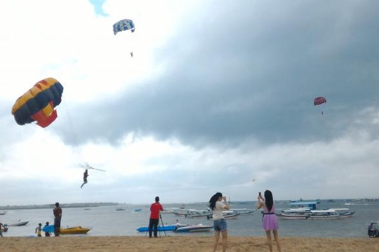 Wisatawan saat bermain parasailing di Pantai Tanjung Benoa