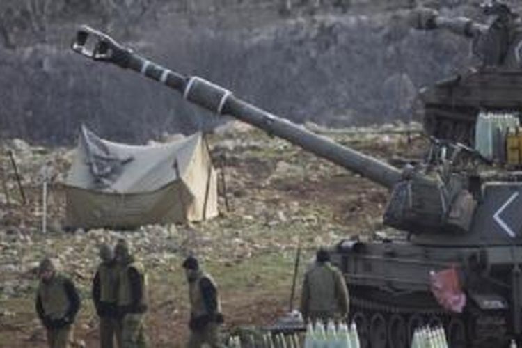 Tentara Israel berdiri dekat unit artileri bergerak di Dataran Tinggi Golan dekat perbatasan dengan Suriah (28/1). 
