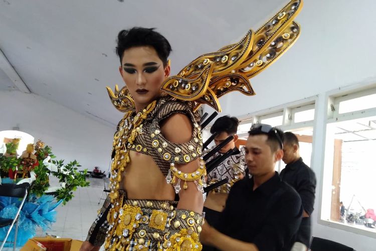 Bubu Ramadhan (baju hitam) saat memasang kostum karnaval The King of Bali di Banyuwangi Ethno Carnoval 2019, Sabtu (27/7/2019)