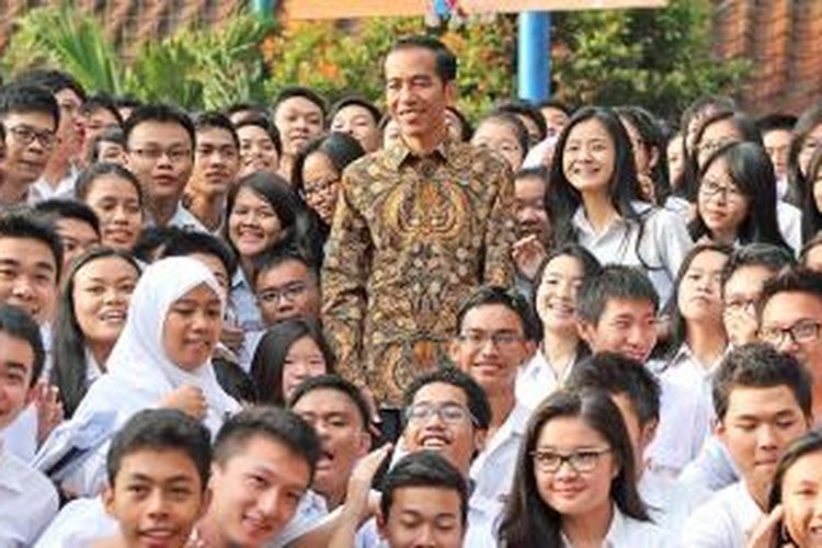 Presiden Joko Widodo berfoto bersama siswa disela-sela  sidak pelaksanaan Ujian Nasional di SMAN 2, Jakarta, Selasa (14/4/2015). Dalam kesempatan itu, Presiden meminta kepada siswa untuk tidak terburu-buru dalam mengerjakan soal dan mendoakan kepada semua siswa di Indonesia agar lulus sekolah.