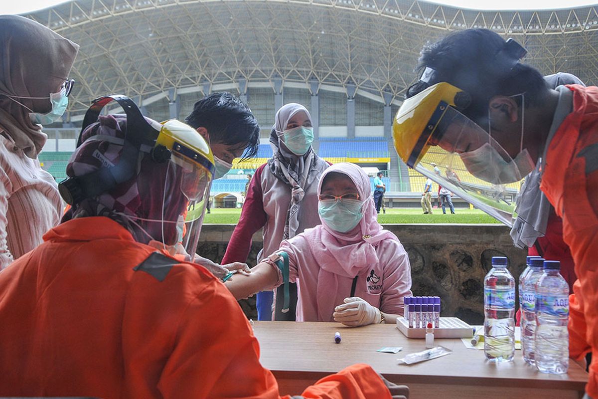 Petugas medis mengecek kesehatannya dengan mengambil sampel  darah dengan metode rapid test (pemeriksaan cepat) di Stadion Patriot Candrabhaga, Bekasi, Jawa Barat, Rabu (25/3/2020). Pemeriksaan yang dilakukan khusus tenaga medis di Bekasi guna memutus mata rantai penyebaran virus COVID-19.