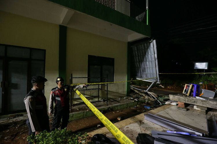 Petugas melihat lokasi tembok bangunan yang roboh di Madrasah Tsanawiyah (MTs) Negeri 19, Jalan Pinang Kalijati, Pondok Labu, Cilandak, Jakarta Selatan, Jumat (7/10/2022). Akibat peristiwa ini 3 orang siswa meninggal dunia dan 3 orang luka-luka.