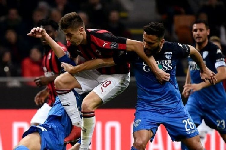 Striker AC Milan, Krzysztof Piatek (kaus merah-hitam) berebut bola dengan bek Empoli Matias Silvestre (kanan) dalam pertandingan Serie A antara AC Milan vs Empoli di Stadion San Siro, Jumat (22/2/2019).