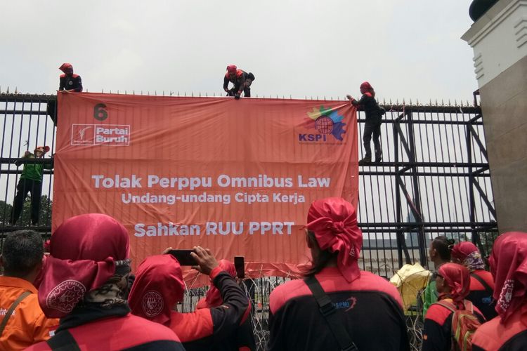 Beberapa massa aksi dari Federasi Serikat Pekerja Metal Indonesia (FSPMI) memang spanduk berisi tuntutan Tolak Perppu Omnibus Law UU Ciptaker dan Sahkan RUU PPRT, Senin, (13/3/2023).
