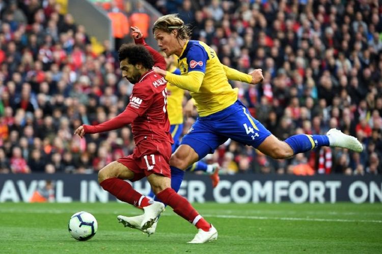 Jannik Verstergaard (kuning) mencoba menahan laju Mohamed Salah dalam pertandingan Liverpool vs Southampton pada lanjutan Premier League di Stadion Anfield, 22 September 2018. 