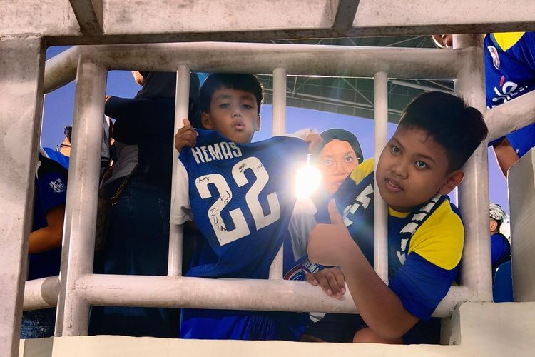 Suporter cilik dari Dendi Santoso Soccer School (DSSS) memamerkan tanda tangan dari pemain Arema FC dan Dewa united pada laga pekan ke-5 Super League 2025-2026 yang berakhir dengan skor 1-2 di Stadion Kanjuruhan Kepanjen, Kabupaten Malang, Sabtu 913/9/2025) sore.