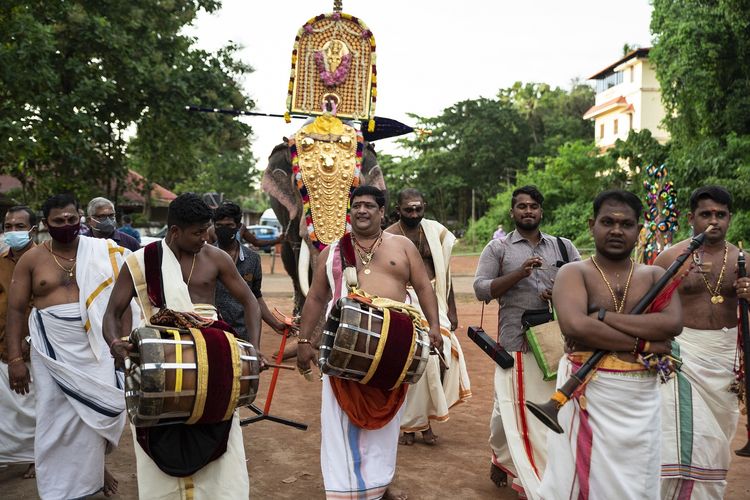 Seniman perkusi memainkan thavil, genderang tradisional, berjalan di depan gajah berpenampilan yang membawa berhala dewa selama festival Onam di kuil Hindu Vamana di Kochi, negara bagian Kerala, India, Jumat, 20 Agustus 2021. [AP Photo/R S Iyer]