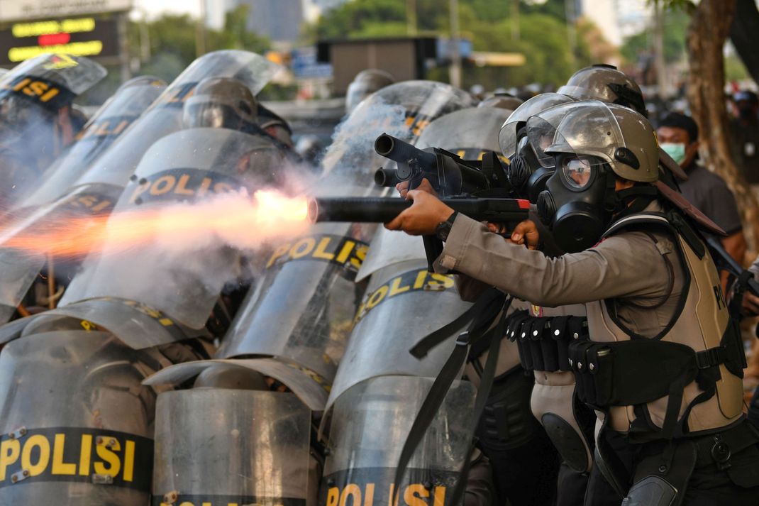 Seorang polisi menembakkan pelontar gas air mata saat kericuhan dalam unjuk rasa di Jalan Gatot Subroto, dekat kompleks Parlemen, Jakarta, Senin (30/9/2019).