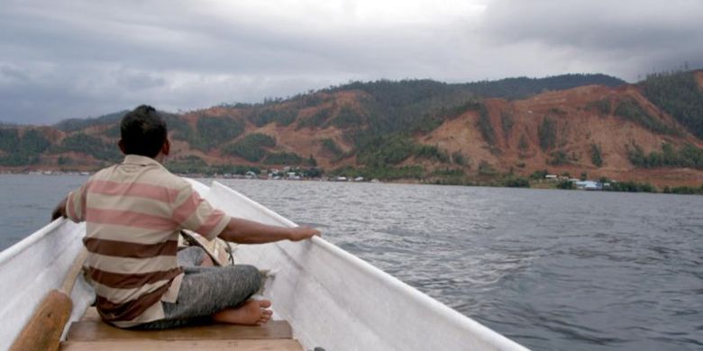 Seorang nelayan memandang lokasi pertambangan nikel di seberang Pulau Labengki selepas memancing ikan