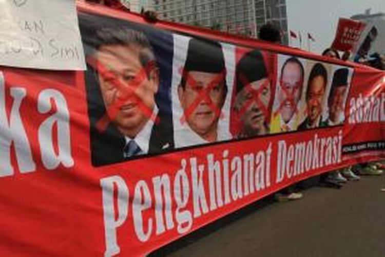 Aktivis pro demokrasi membawa spanduk bergambar ketua umum partai pendukung pilkada oleh DPRD saat unjuk rasa di Bundaran HI Jakarta, Minggu (28/9/2014). Mereka mengumpulkan fotokopi KTP dan tandatangan warga untuk menggugat UU Pilkada ke Mahkamah Konstitusi.