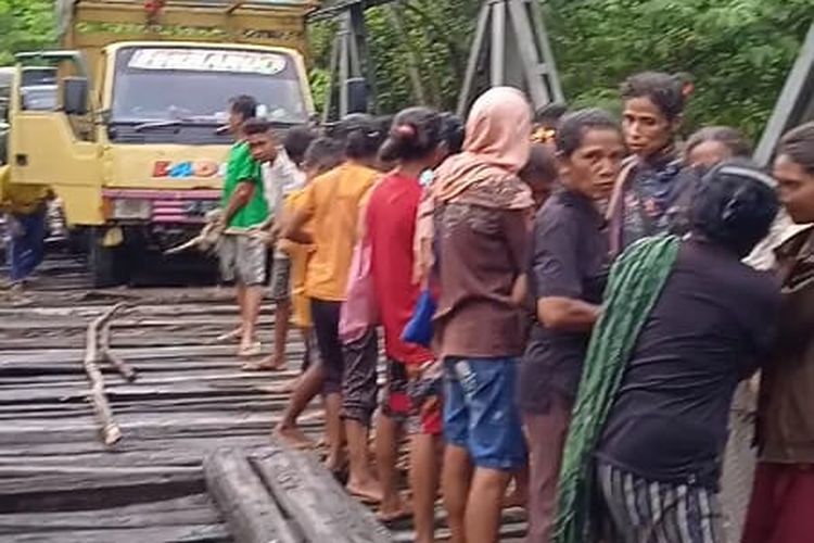 Ibu-ibu asal Desa Honuk, Kecamatan Amfoang Barat Laut, Kabupaten Kupang, Nusa Tenggara Timur (NTT), menarik sebuah truk yang tersangkut di jembatan
