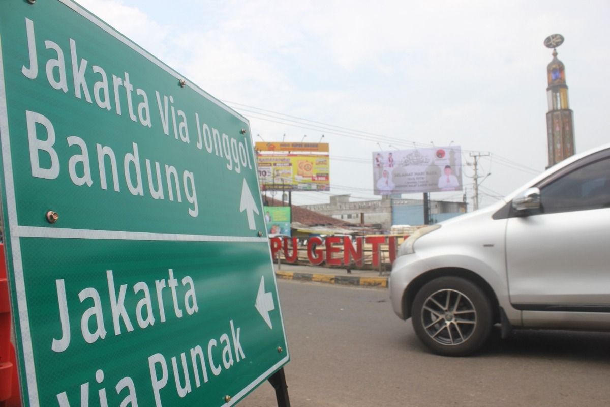 Kendaraan saat melintas melewati plang penunjuk jalan di ruas jalur mudik di Kabupaten Cianjur, Jawa Barat.