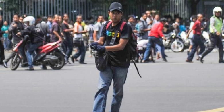 Foto ini dirilis oleh agensi berita China Xinhua, seorang pria tak dikenal dengan senjata, terduga pelaku, terlihat setelah ledakan menghantam kawasan Jalan MH Thamrin, Jakarta Pusat, 14 Januari 2016. Serangkaian ledakan menewaskan sejumlah orang, terjadi baku tembak antara polisi dan beberapa orang yang diduga pelaku.