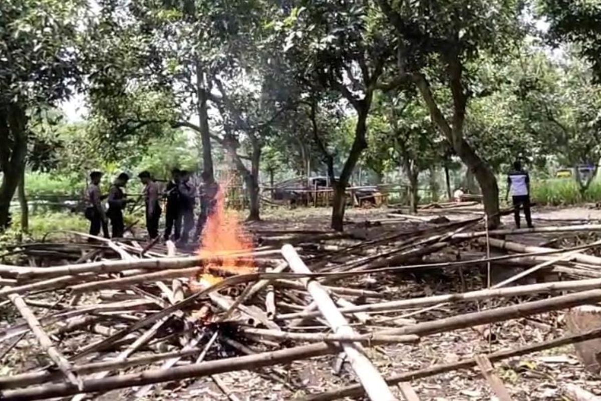 Polres Pasuruan Kota melakukan pemusnahan lokasi sabung ayam dengan membongkar dan membakar bangunan semi permanen di Desa Sebalong, Kecamatan Nguling, Kabupaten Pasuruan, Jawa Timur, Kamis (17/04/2025) 
