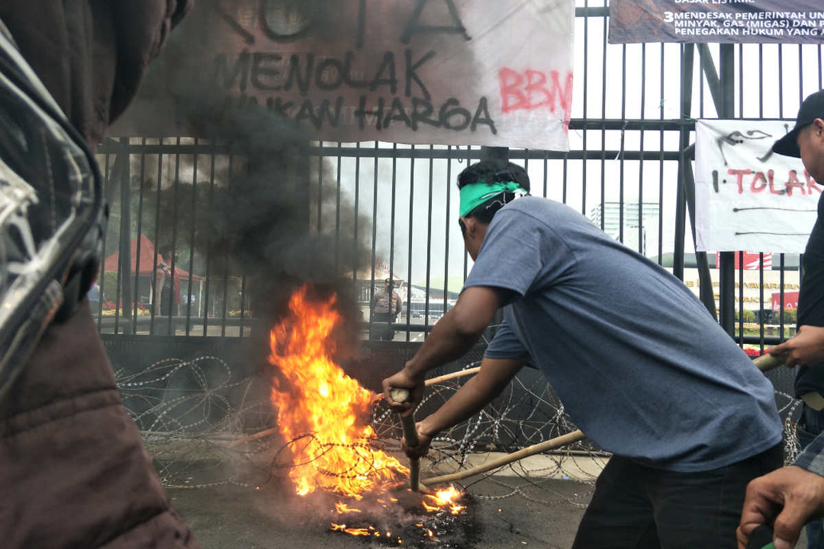 Massa dari organisasi Himpunan Mahasiswa Islam (HMI) membakar ban saat aksi demonstrasi di depan Gedung DPR/MPR, Jakarta Pusat, Senin (29/8/2022).