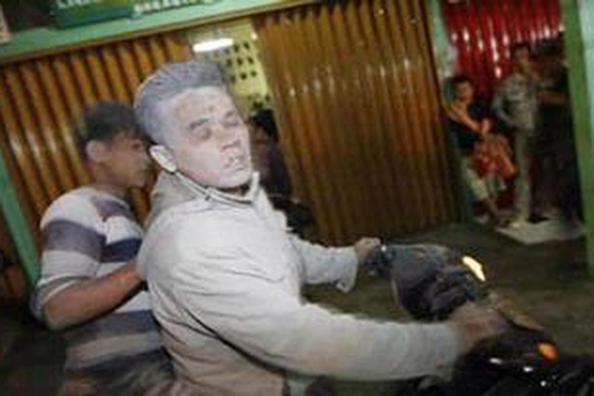 Warga panik akibat letusan gunung Sinabung dan berbondong-bondong mengungsi mengki menembus hujan abu, Minggu (29/8/2010). Tampak wajah pengendara sepeda motor itu terkena abu selama perjalanan menjauh dari gunung.