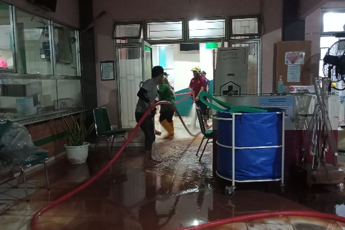 Tim damkar dan warga bergotong-royong membersihkan tanah merah yang terbawa banjir di Puskesmas Rawa Buntu, Serpong, Tangerang Selatan pada Jumat (23/8/2022) sore.