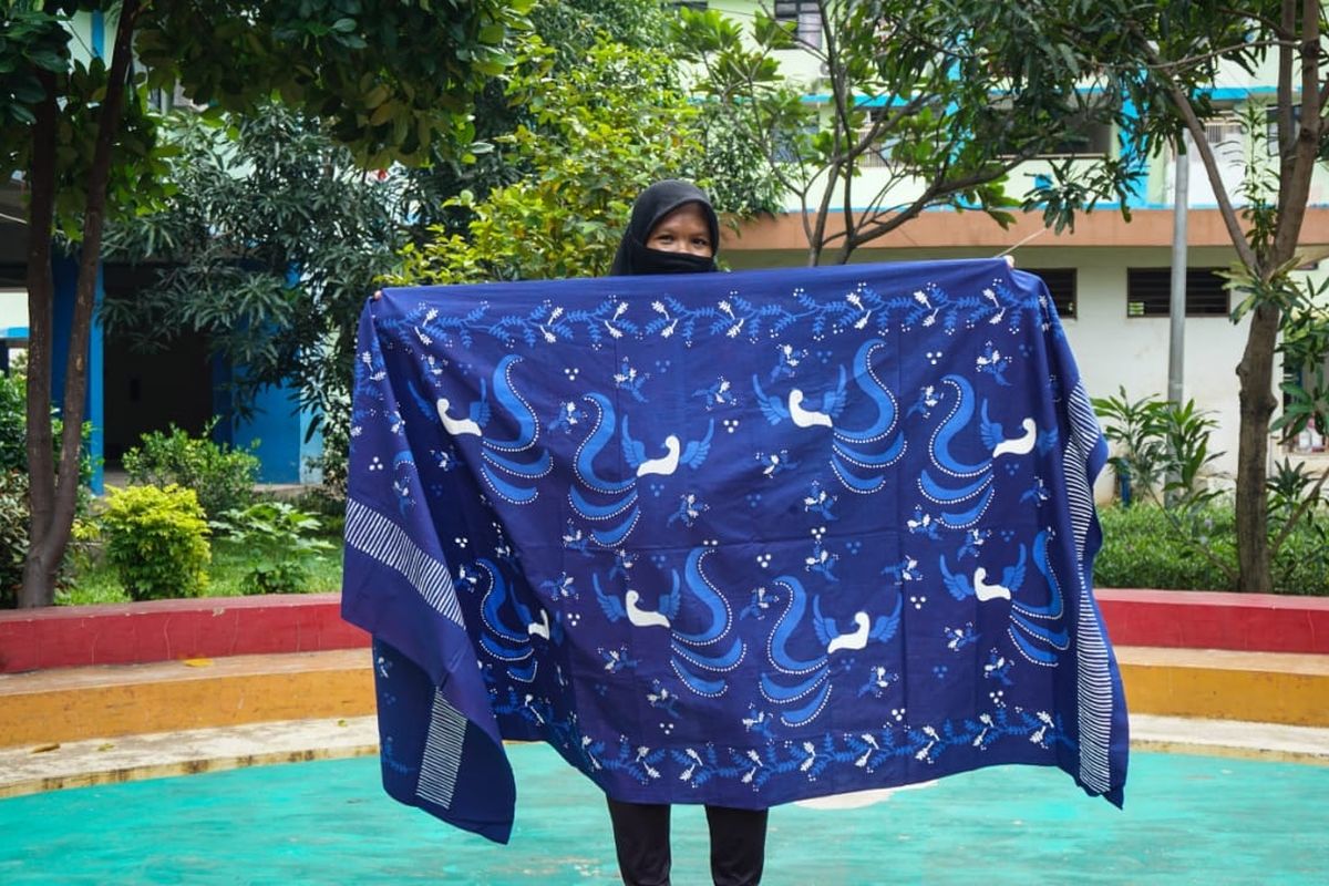 Eni (39), warga Rusun Pulogebang, menunjukkan kain batik tulis yang ia lukis, Jumat (18/6/2021). Eni merupakan salah satu korban gusuran yang kini berjuang memungut kembali sisa-sisa masa kejayaannya sebelum digusur dengan cara aktif terlibat sebagai pengrajin batik.