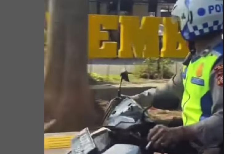 Video yang memperlihatkan seorang polisi lalu lintas terlihat merokok sambil mengendarai sepeda motor.
