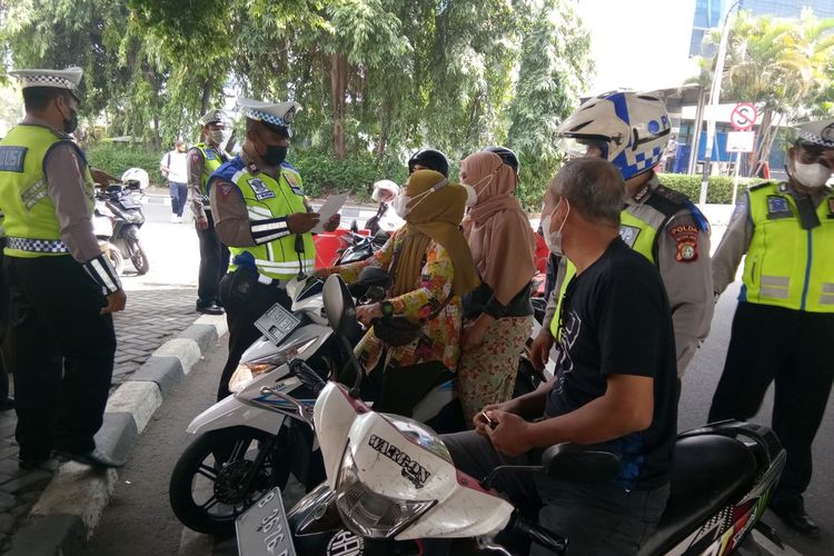 Satlantas Polres Metro Jakarta Barat menyosialisaskan tentang operasi Zebra Jaya 2022 kepada para pengendara sepeda motor yang melanggar lalu linta di kolong flyover Hotel Peninsula, Jalan Letjen S Parman, Jakarta Barat, Senin (3/10/2022).  