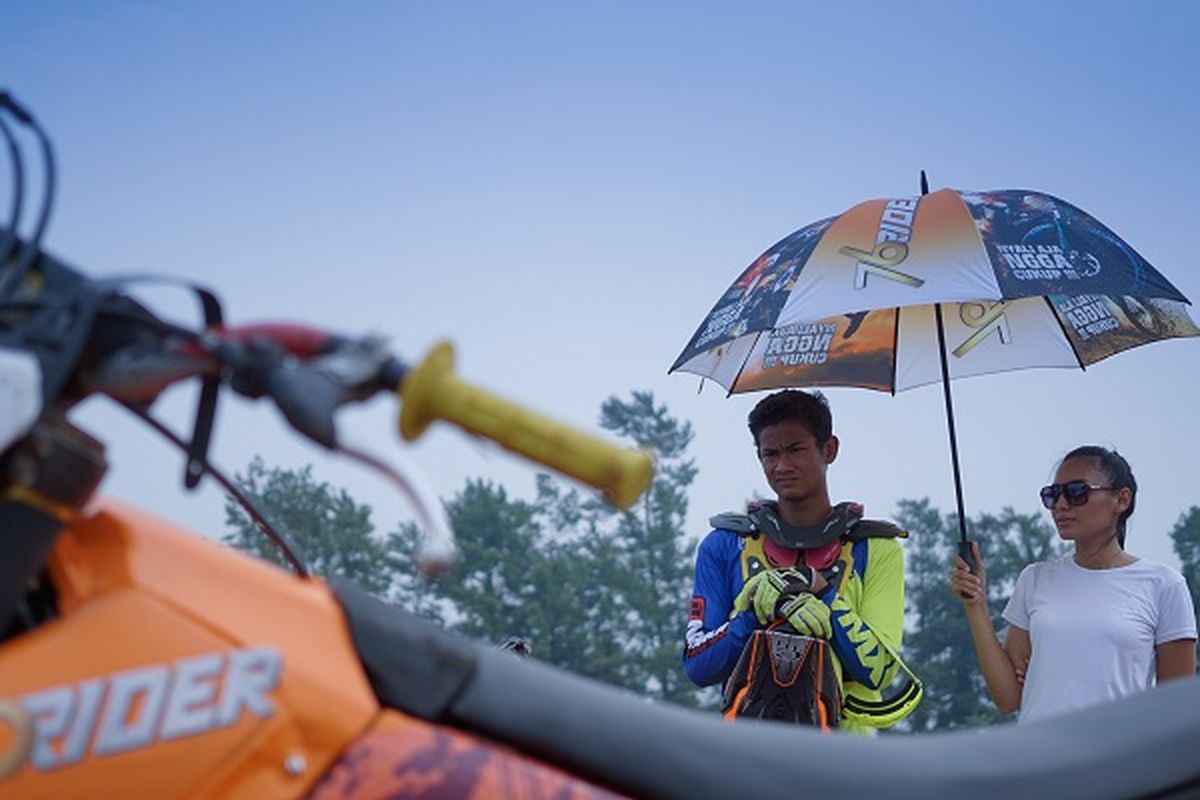 Kroser sekaligus freestyle motocross Zulmi Aristiawan sedang dipayungi umbrella girl di Sirkuit Paramount, Bumi Serpong Damai, Tangerang, Banten, ketika melakukan syuting TVC 76 Rider. 