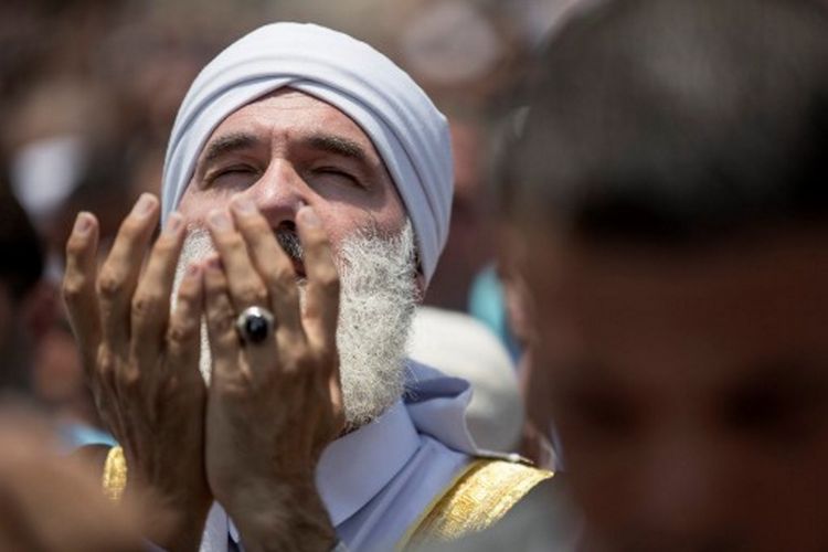 Warga Palestina menjalankan ibadah Shalat Jumat di luar pintu masuk menuju kawasan Kota Tua Yerusalem di depan Masjid Al-Aqsa, Jumat (21/7/2017).  Israel melarang pria Palestina yang berusia di bawah 50 tahun untuk masuk ke kawasan Kota Tua dan menjalani Shalat Jumat, menyusul insiden penembakan dua polisi Israel.