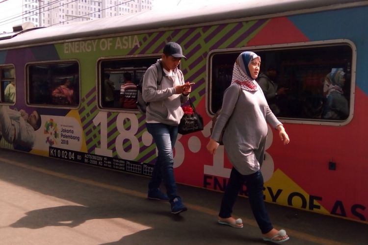 Penumpang berjalan di sisi gerbong kereta api yang berlukiskan tema Asian Games 2018 di Stasiun Besar Kota Bekasi, Sabtu (28/4/2018). Asian Games 2018 digelar di Jakarta dan Palembang mulai 18 Agustus 2018 hingga 2 September 2018. 