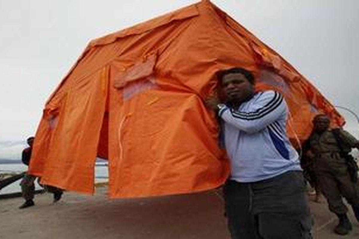 Volunteers carry a temporary shelter for a villager who lost his home after flooding hit Wasior village in Indonesias Papua province October 9, 2010. At least 126 people died, 66 went missing and more than 800 injured after flash floods swept Wasior on Monday, according to data from Indonesias National Disaster Mitigation Agency on Saturday.